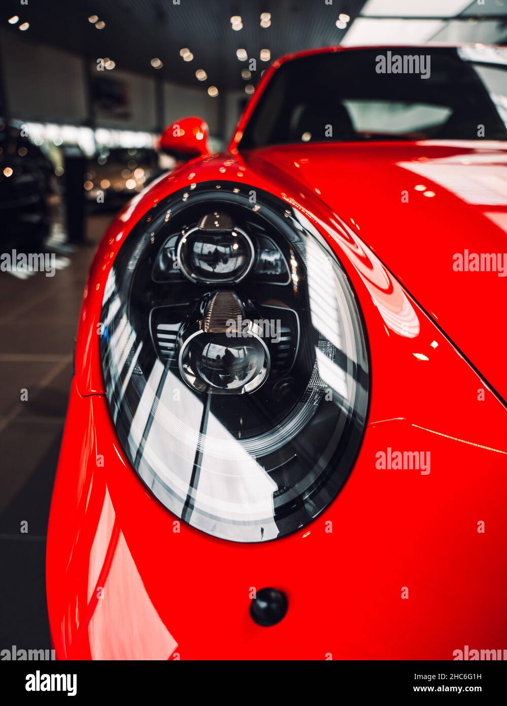 Caro supercoche rojo que se muestra en la sala de exposición de un concesionario de coches Foto de stock