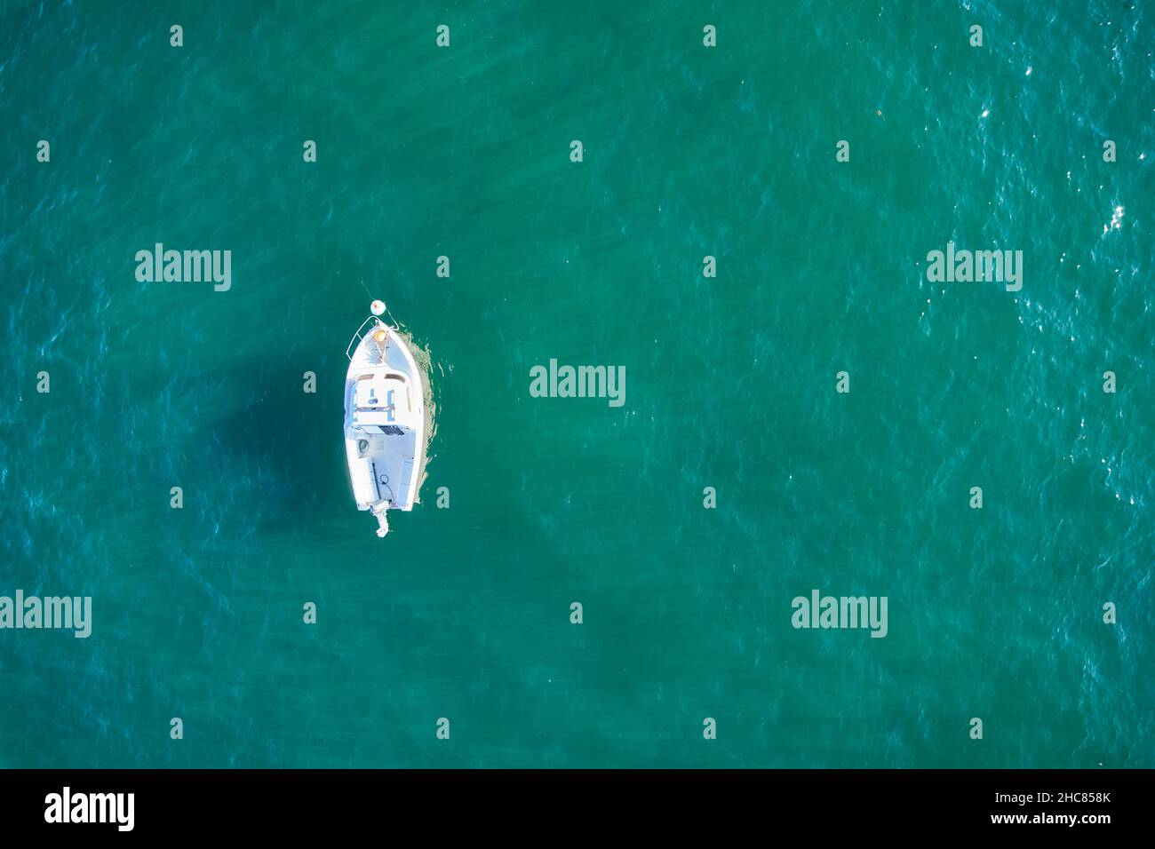 Barco de pesca vacío desde arriba en el atlántico. Vista aérea de un pequeño barco blanco sobre aguas verdes del mar. Objeto aislado. Foto de stock