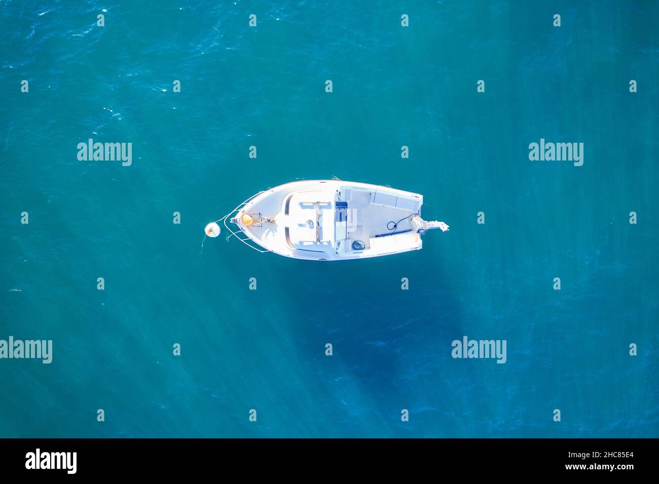 Barco de pesca vacío desde lo alto del atlántico. Vista aérea de un pequeño barco blanco sobre el agua azul del mar. Objeto aislado. Francia. Foto de stock