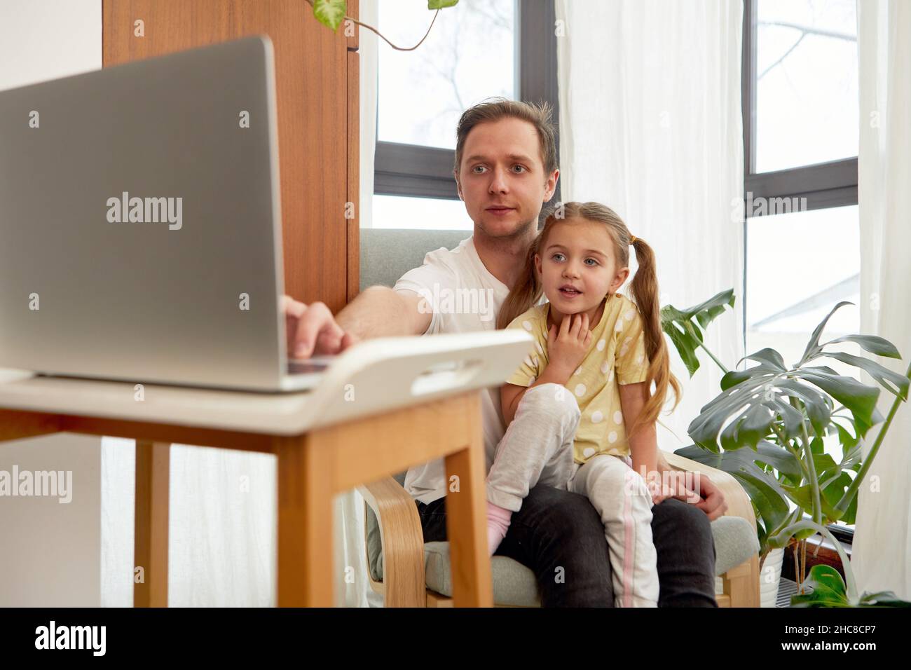 Concepto de educación. Feliz padre enseñando a su pequeña niña cómo usar la computadora personal, espacio de copia Foto de stock