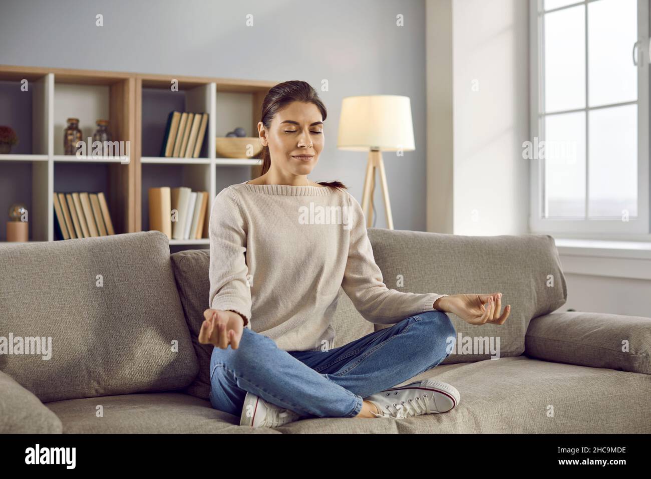 Mujer tranquila medita Practica yoga en casa Foto de stock