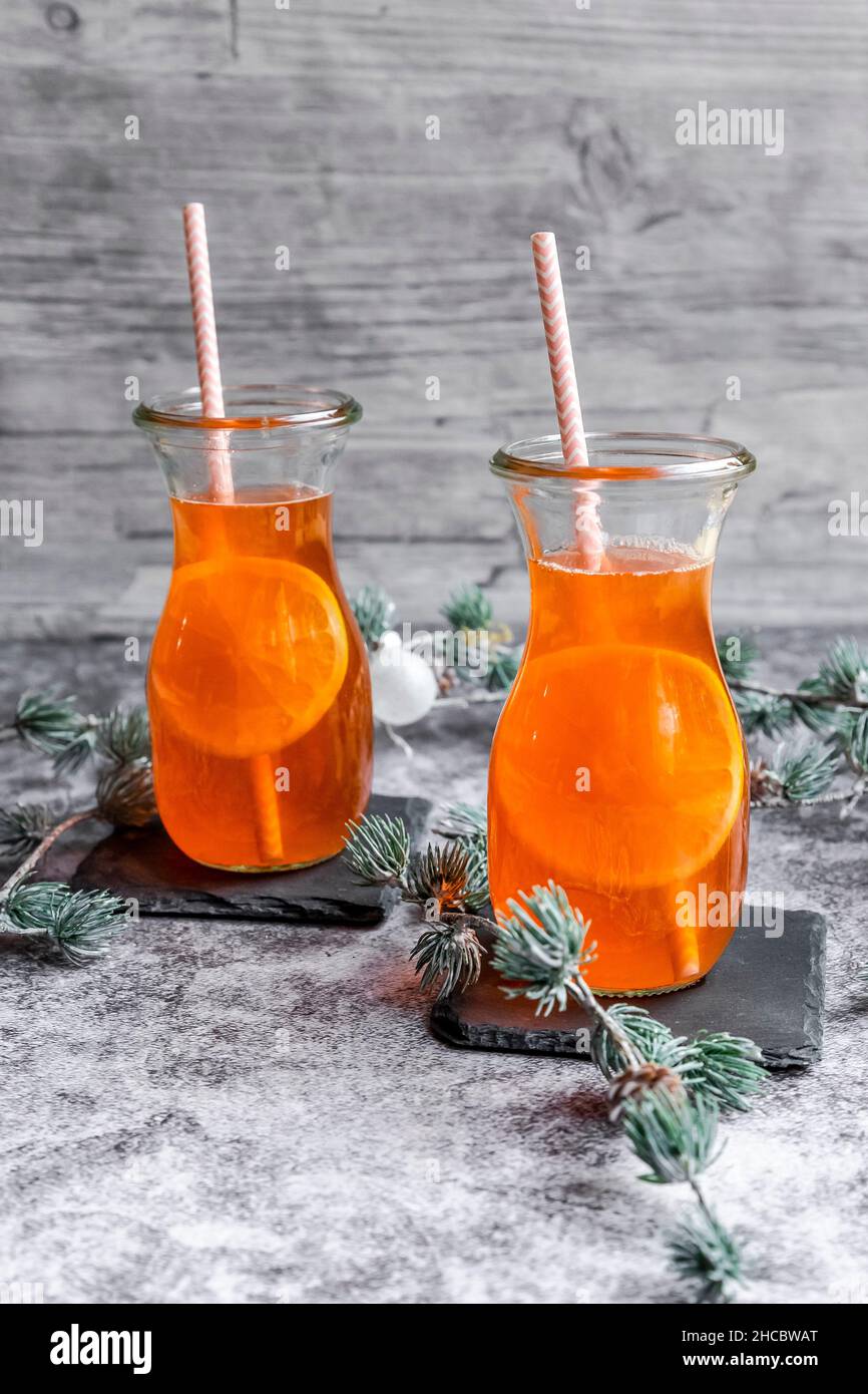 Estudio de ramitas y dos botellas de Aperol caliente con rodajas de naranja Foto de stock