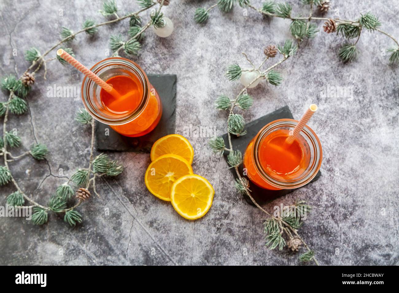 Estudio de ramitas y dos botellas de Aperol caliente con rodajas de naranja Foto de stock