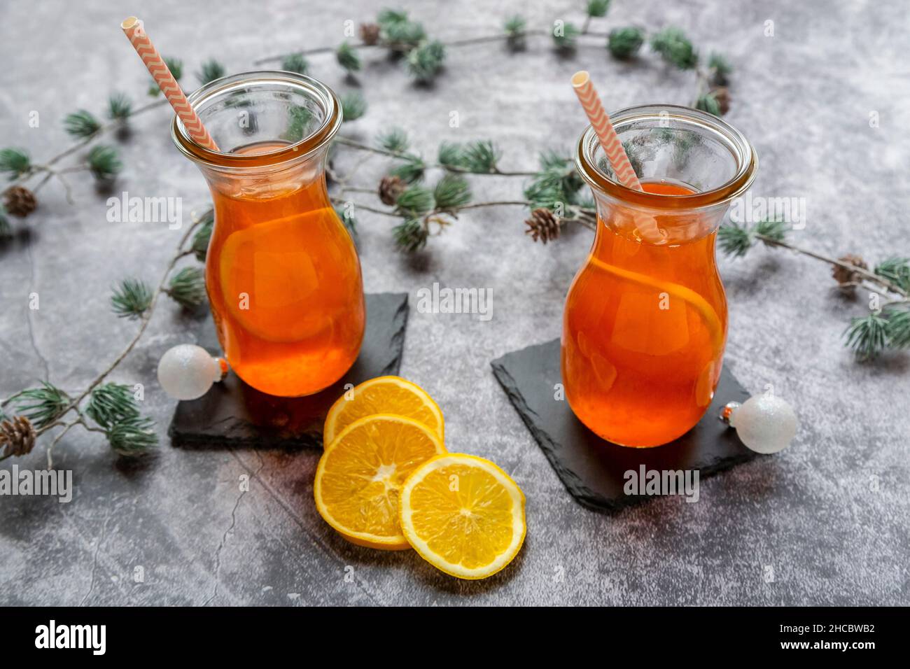 Estudio de ramitas y dos botellas de Aperol caliente con rodajas de naranja Foto de stock