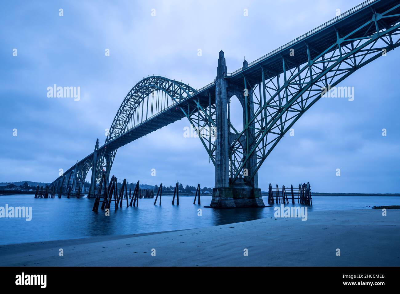 Pilones de madera y Yaquina Bay Bridge, Newport, Oregon, EE.UU. Foto de stock