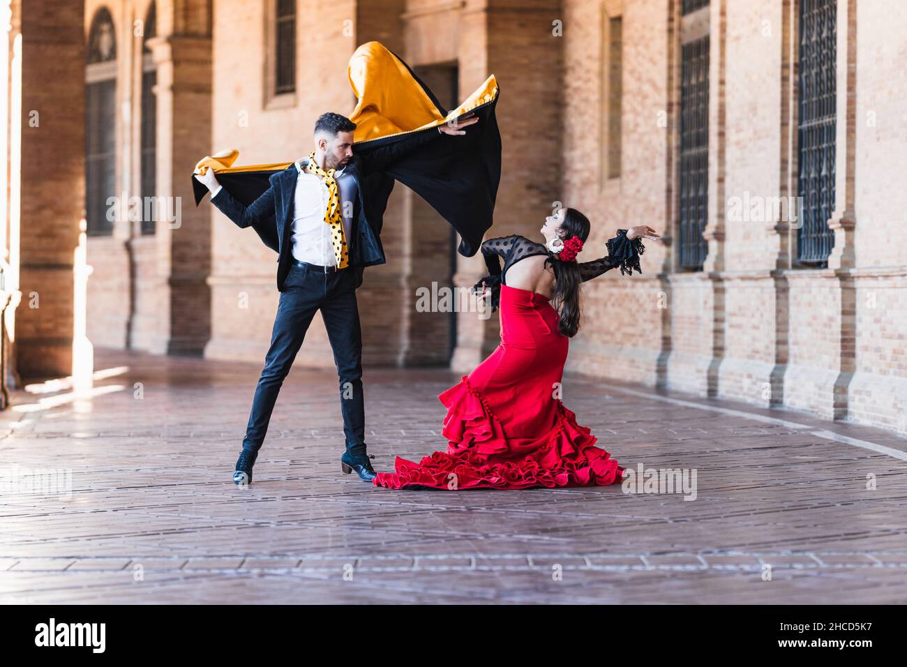 EL FLAMENCO, UNA TRADICIÓN ESPAÑOLA Hombre-y-mujer-con-traje-flamenco-bailando-al-aire-libre-2hcd5k7