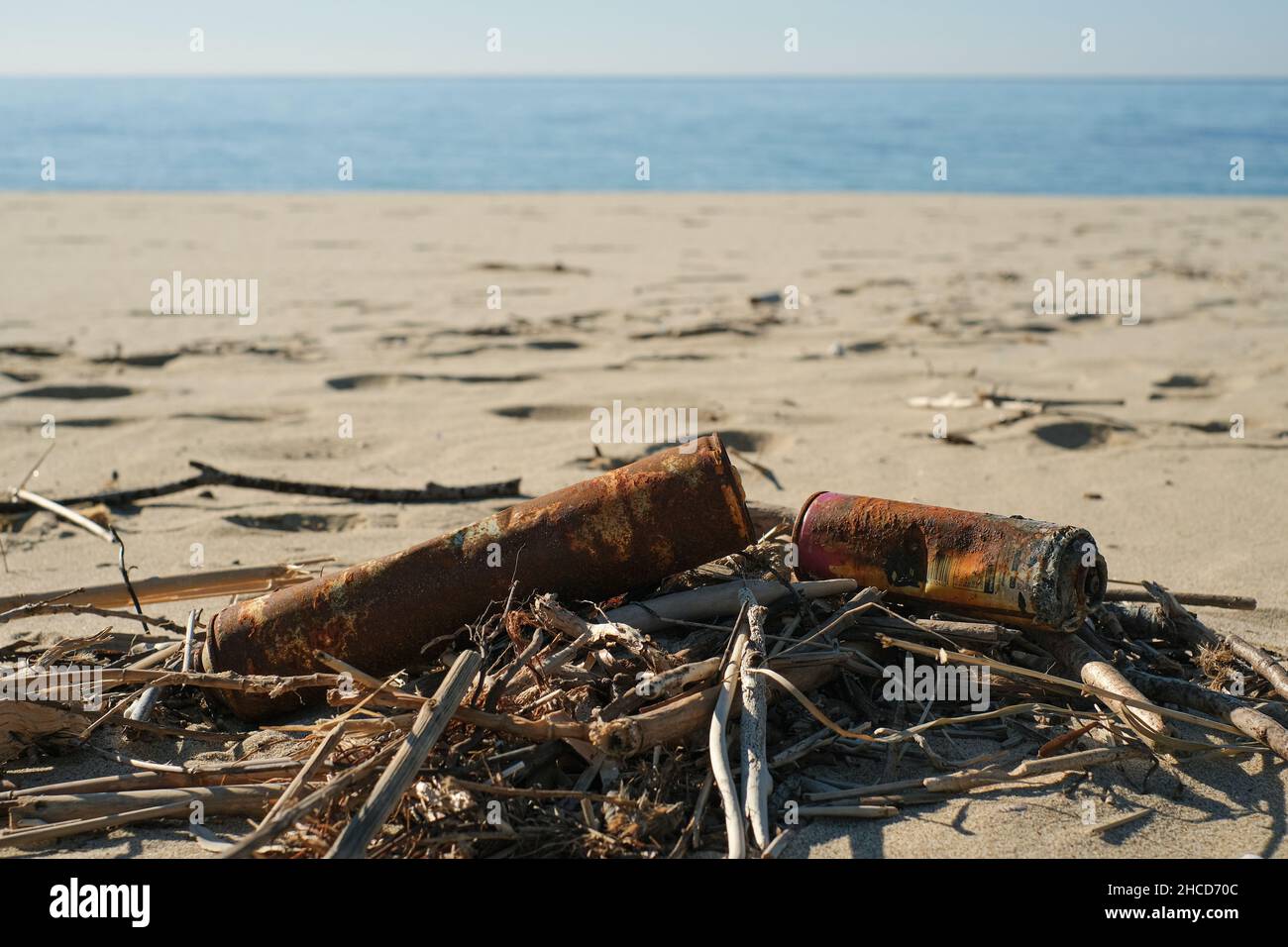 Viejas latas de aerosol oxidadas desechadas en el ecosistema de la costa del mar, contaminación de la naturaleza Foto de stock