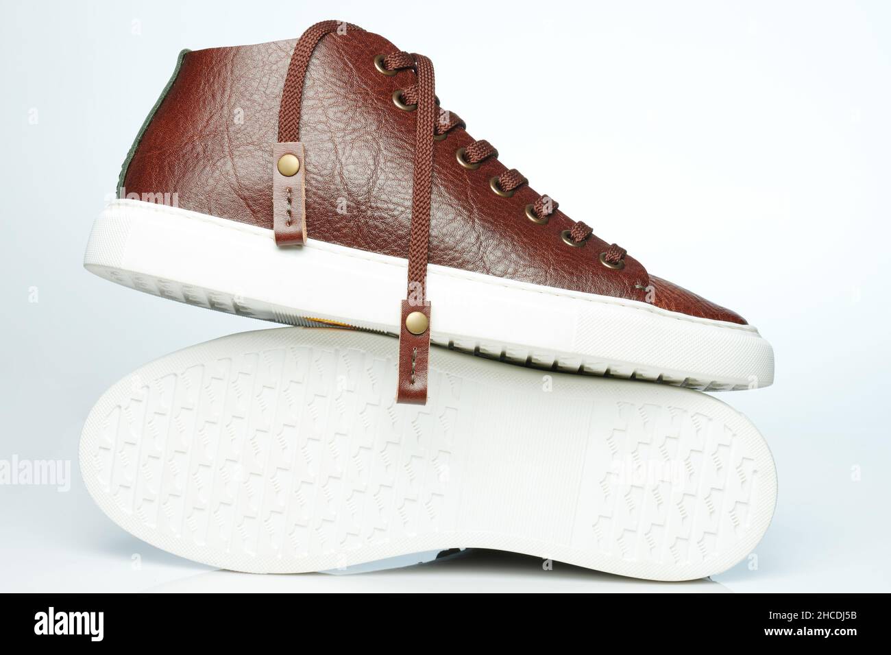 Suela de caucho blanco con sneakers de piel marrón aisladas Foto de stock