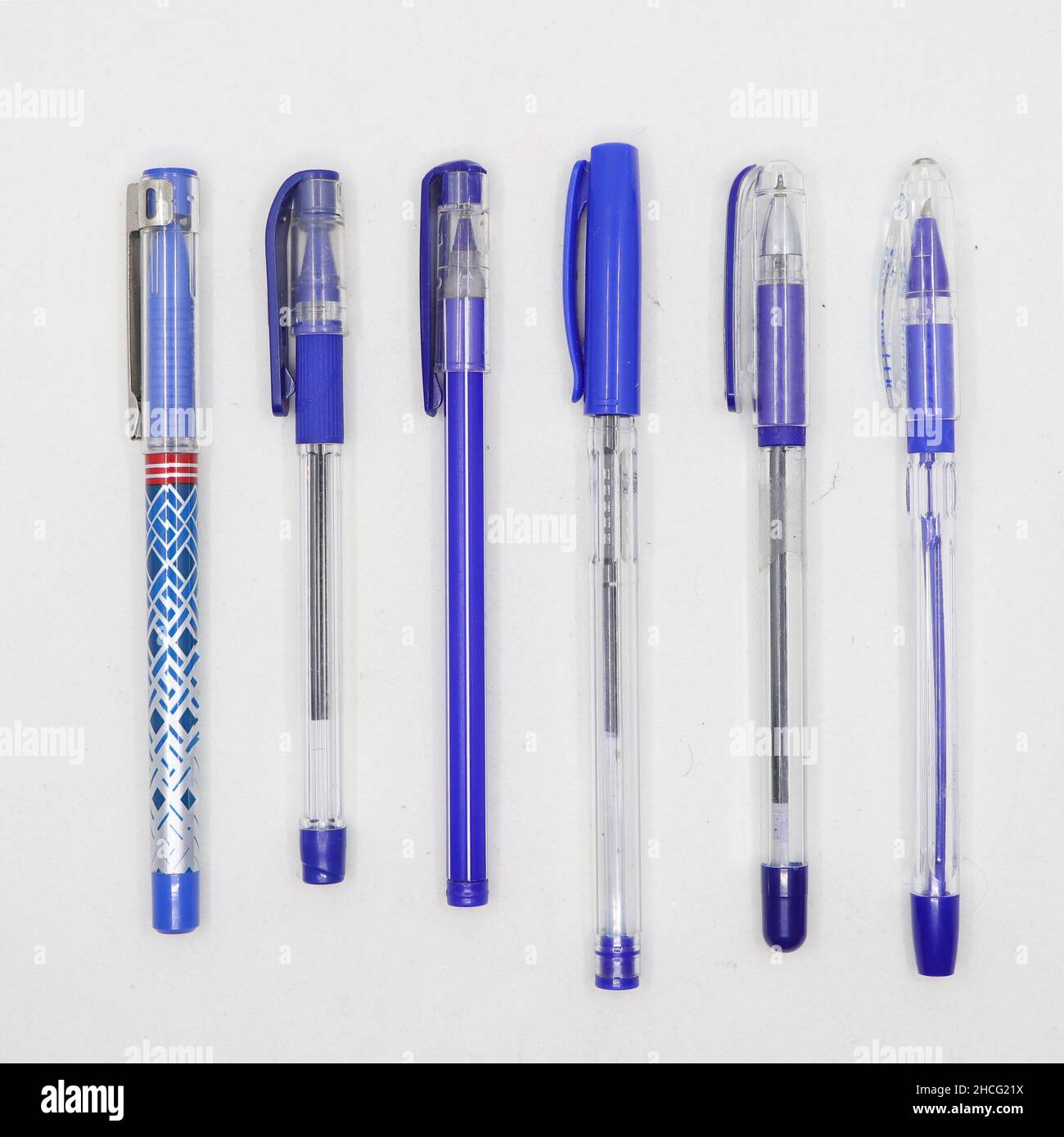 Bolígrafos azules y un bolígrafo amarillo sobre fondo azul vista superior  concepto de diferencia