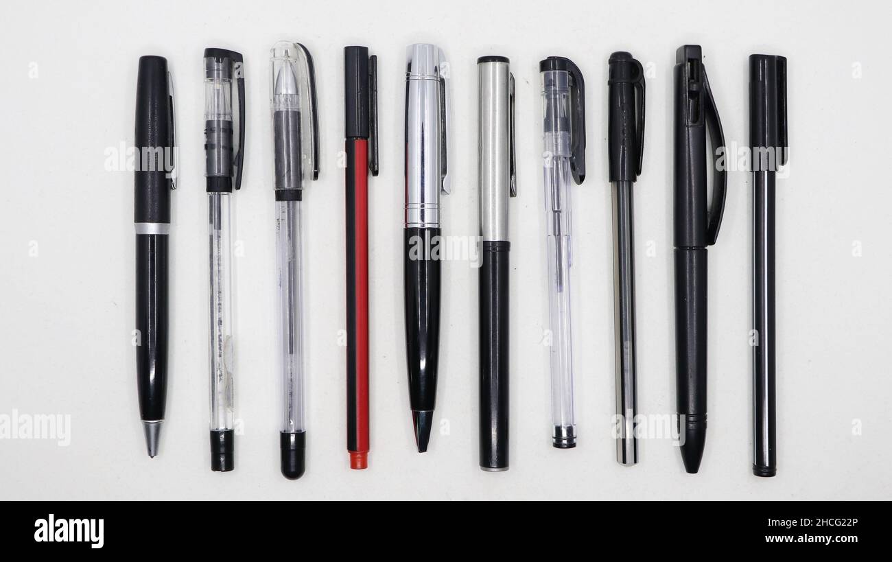 disparo horizontal de un grupo de diferentes tipos de bolígrafos negros  dispuestos paralelos entre sí aislados en un fondo blanco Fotografía de  stock - Alamy