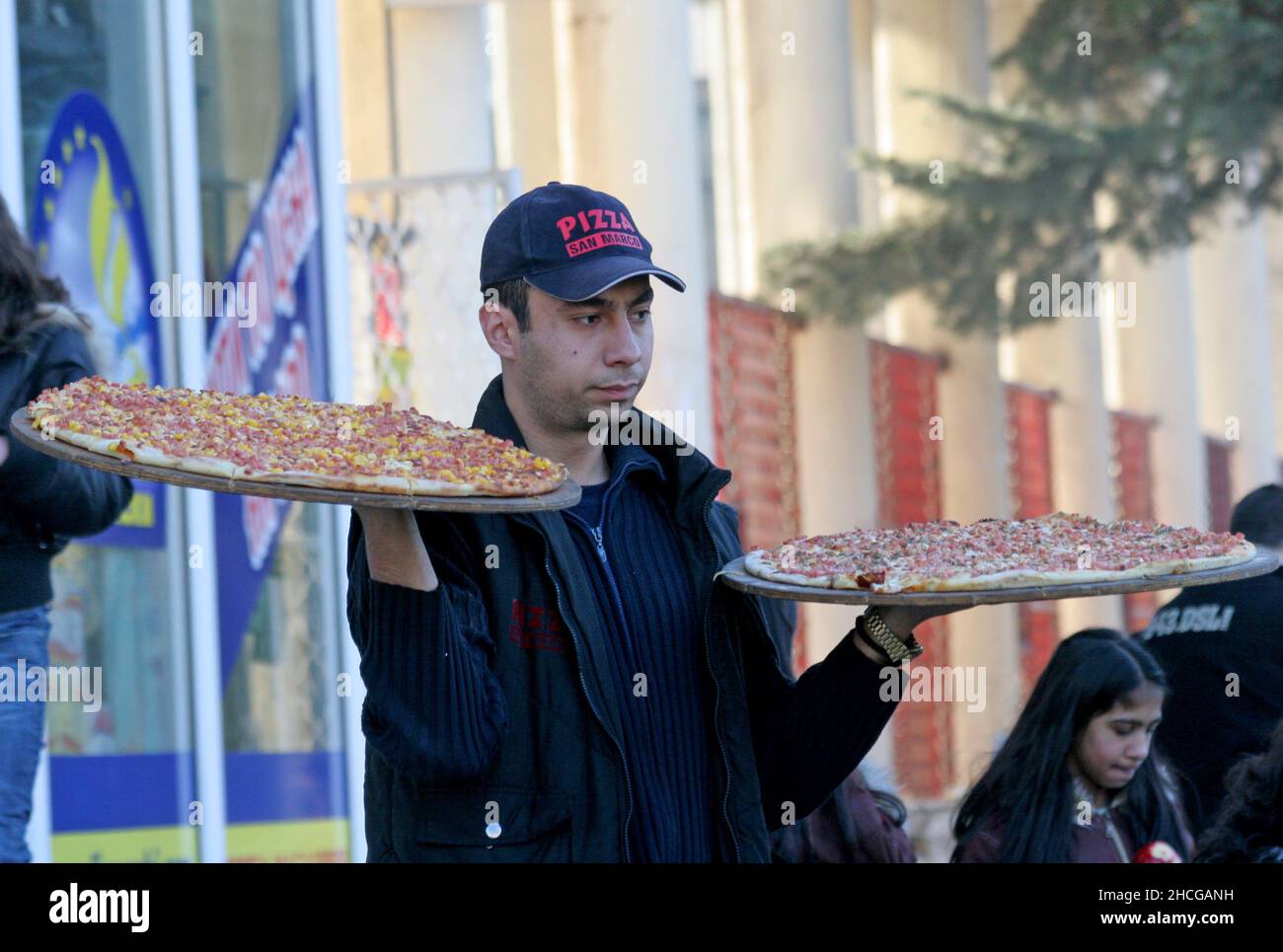 El tipo de entrega está trayendo dos pizzas grandes en la pizzería en Sofía, Bulgaria el 26 de enero de 2008. Foto de stock