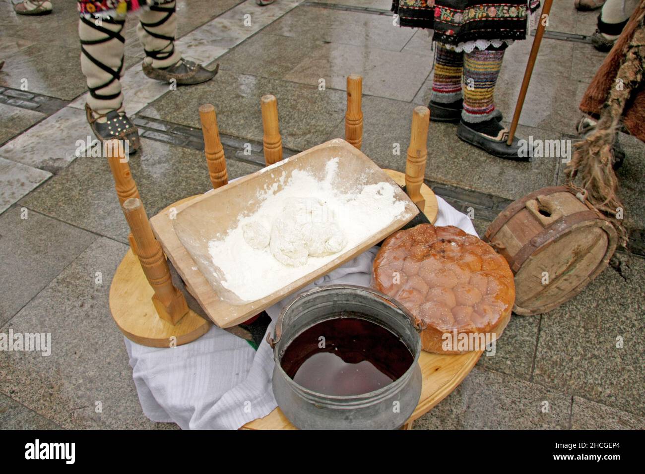 Mesa con comida tradicional búlgara pan pitka, amasar masa y cobre menche ot buklitsa. Foto de stock