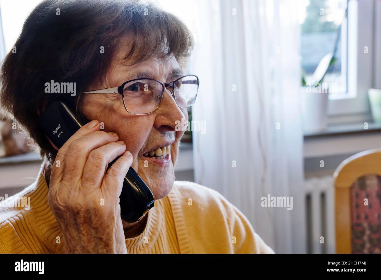 Mujer mayor en casa hablando por teléfono, Colonia, Renania del Norte-Westfalia, Alemania Foto de stock