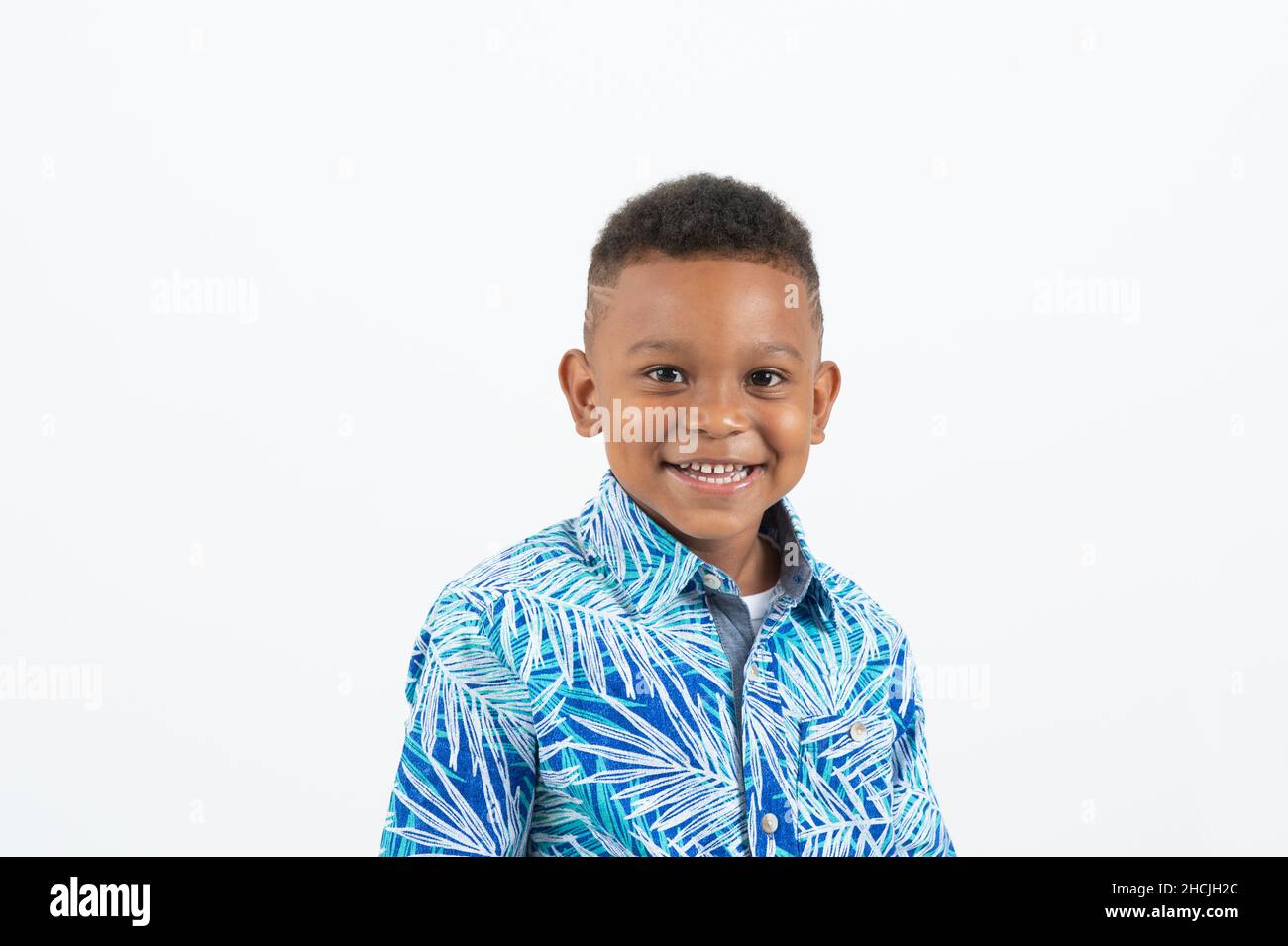 Primer plano retrato de un niño de 4 o 5 años, sonriente, fondo blanco, Foto de stock