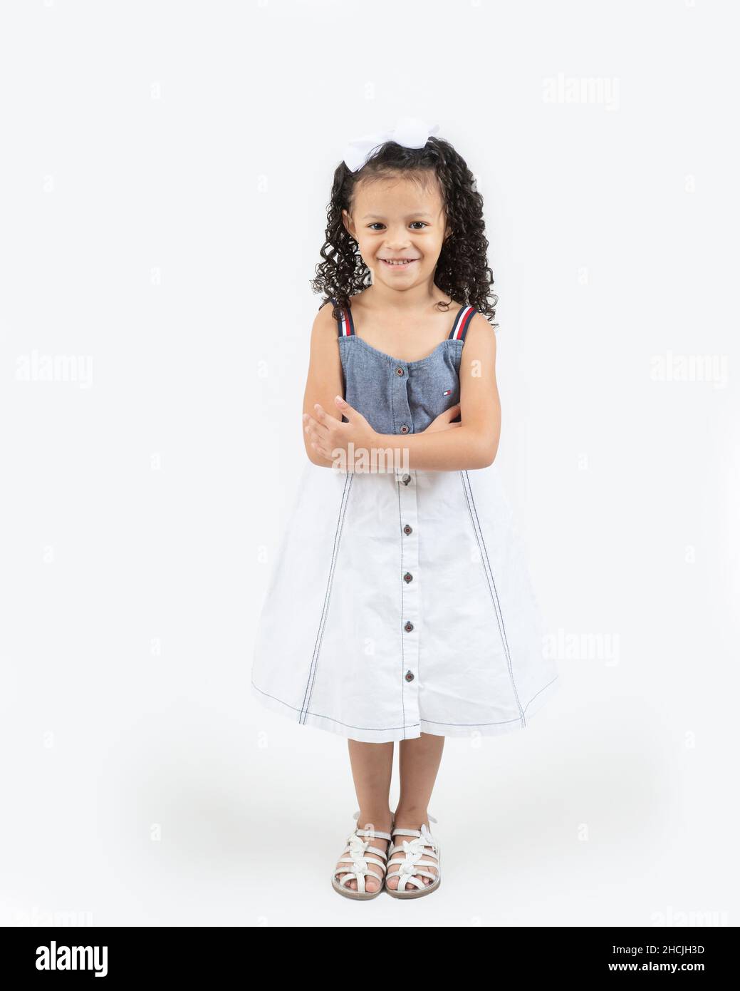 Primer plano retrato de una niña de 4 años, sonriente, fondo blanco, largo completo Foto de stock