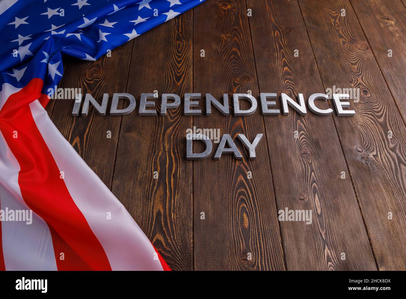 las palabras día de la independencia se colocaron en la superficie de tablones de madera marrón con la bandera unated estados de américa arrugada Foto de stock