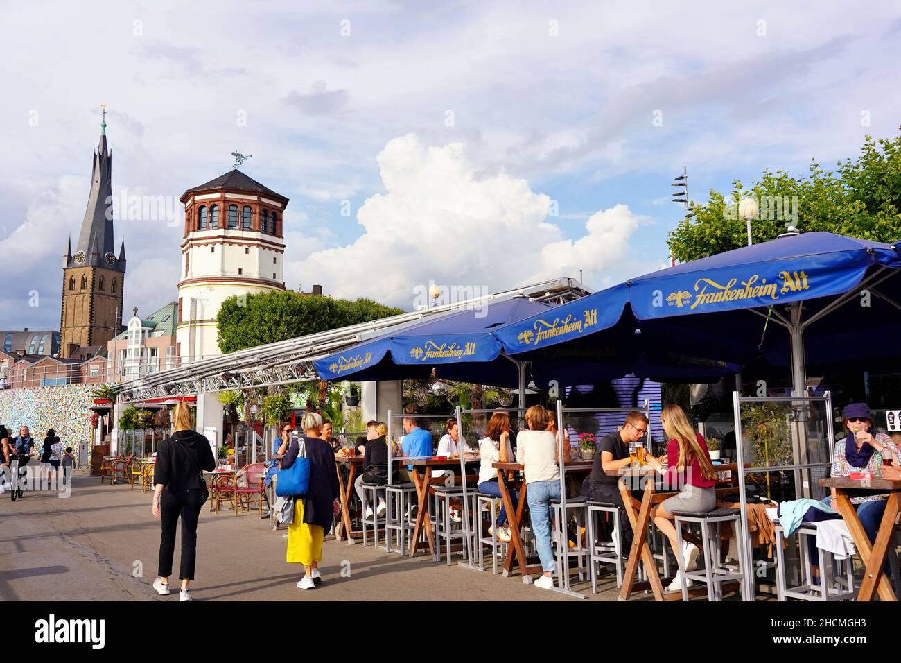 La popular atracción turística del paseo del río Rin en Düsseldorf/Alemania con gente sentada en restaurante al aire libre. Foto de stock