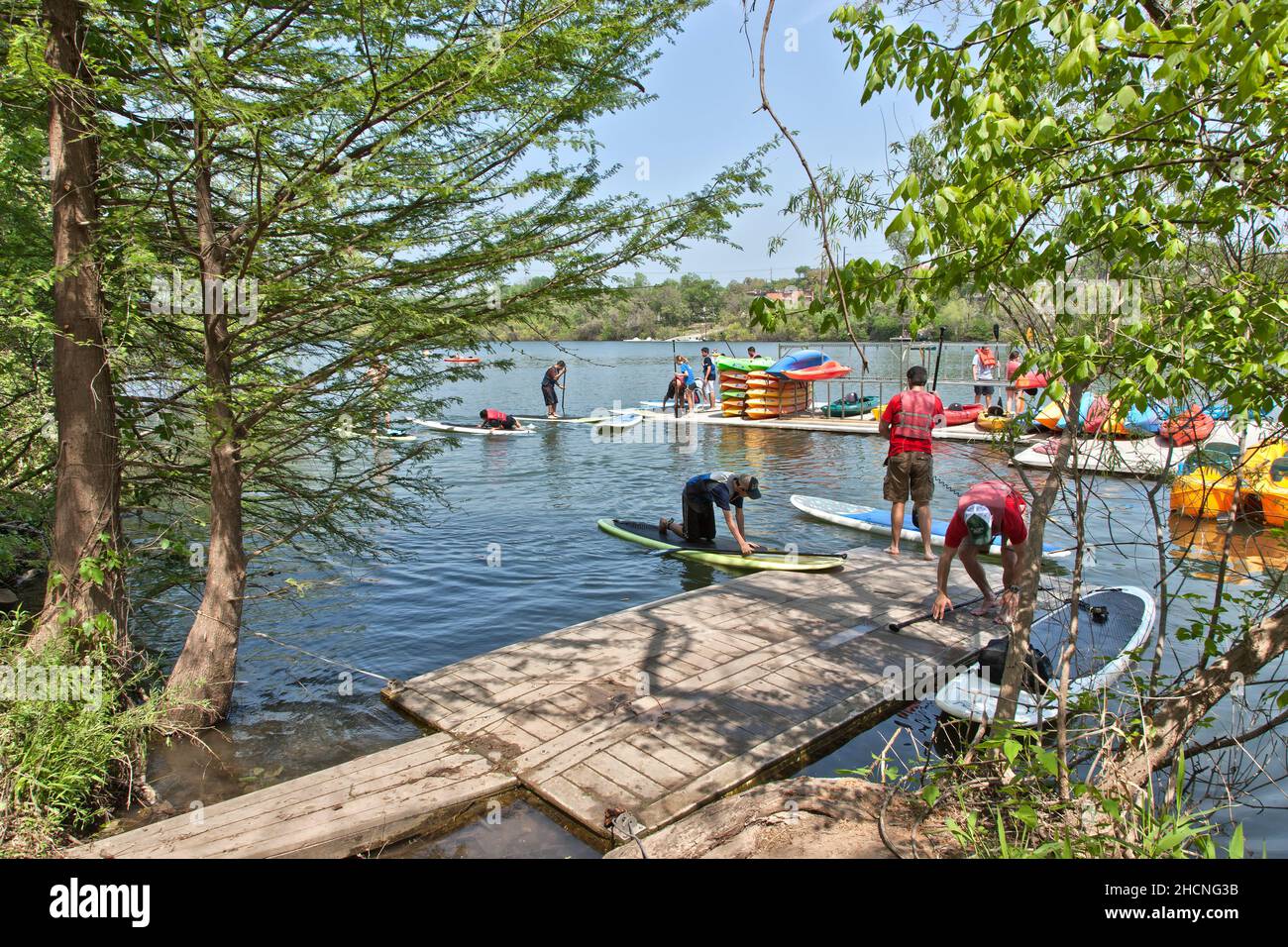Alquiler de paddle y kayak, entusiastas del deporte que se preparan para manipular en el río Colorado, Lady Bird Lake, Austin, Texas. Foto de stock