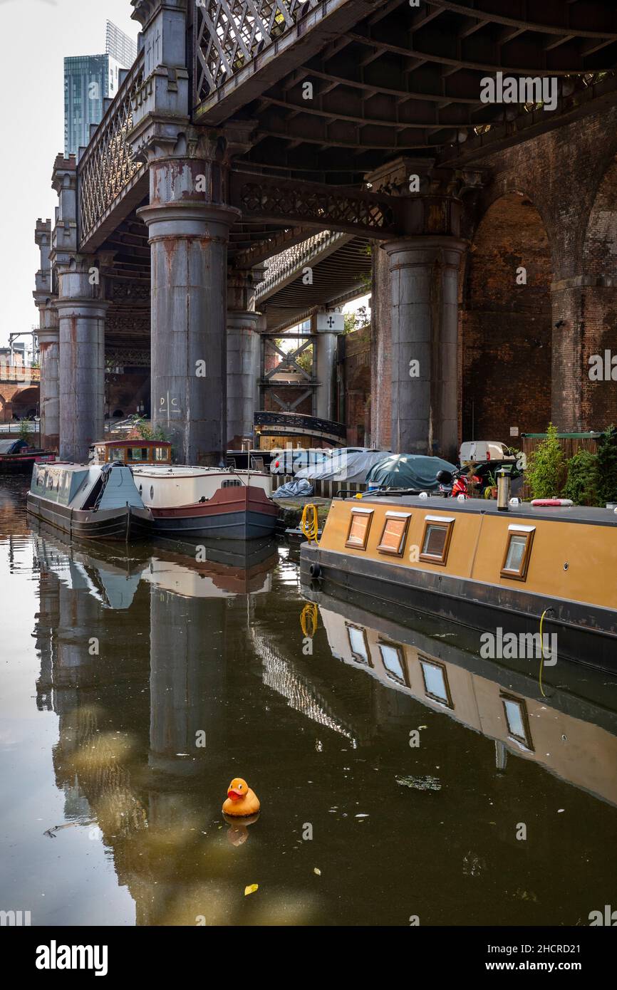 Reino Unido, Inglaterra, Manchester, Castlefield, cuenca del canal Bridgewater, canal residencial narrowboat debajo del viaducto de ferrocarril redundante Foto de stock