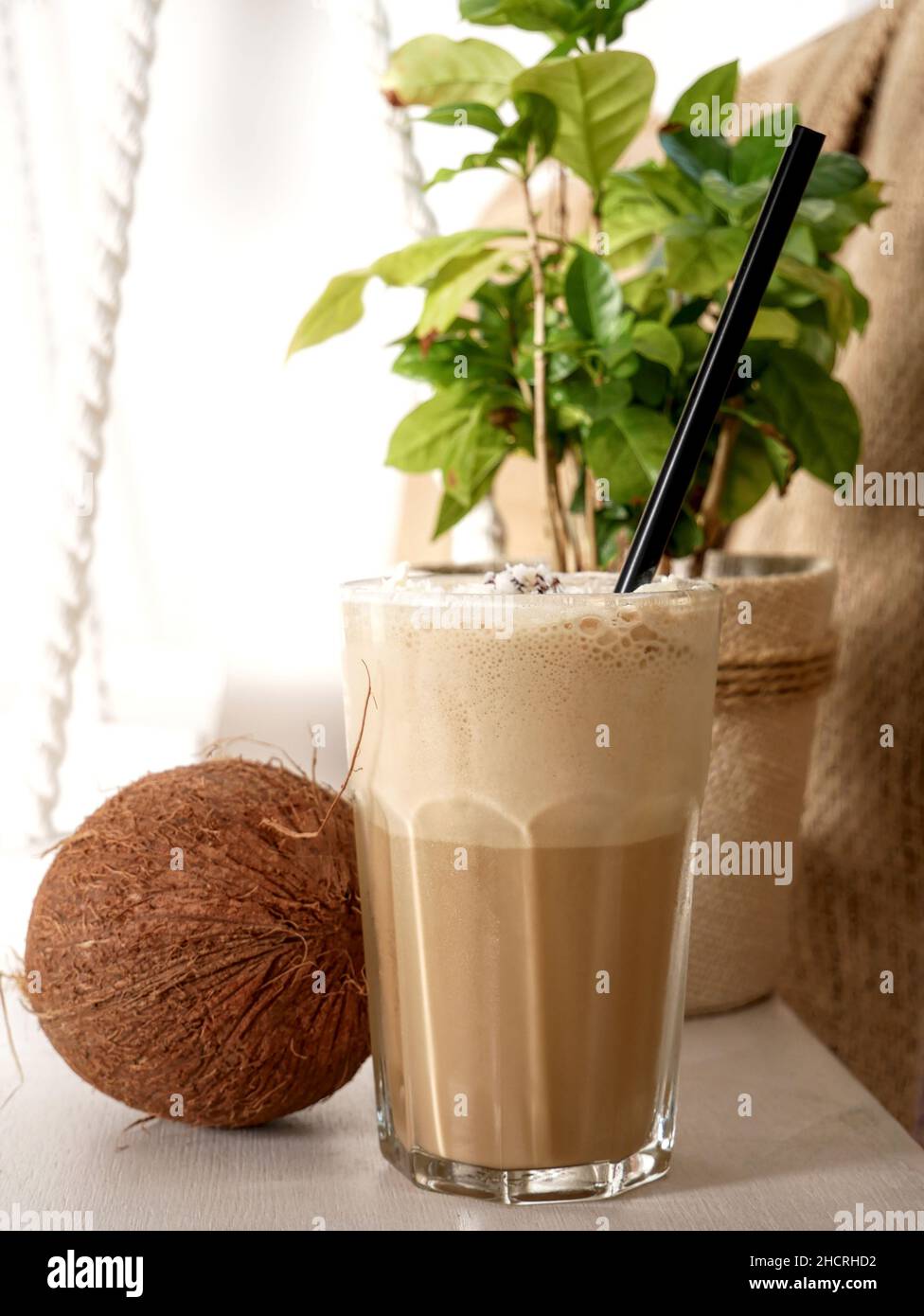 Café con leche de coco en un vaso alto y coco en un columpio. Primer plano  Fotografía de stock - Alamy