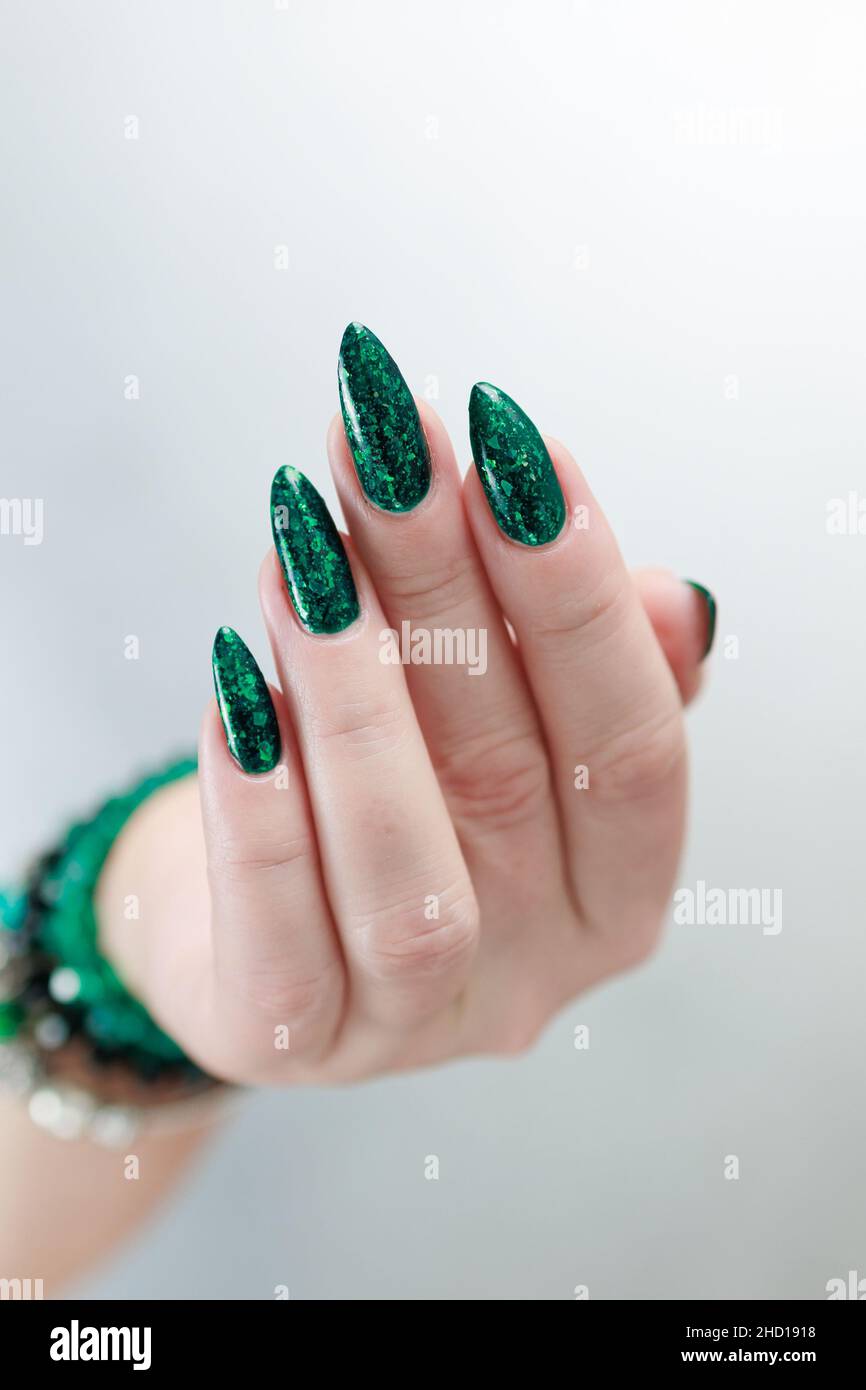 Mano de mujer con uñas largas y esmalte verde esmeralda Fotografía de stock  - Alamy