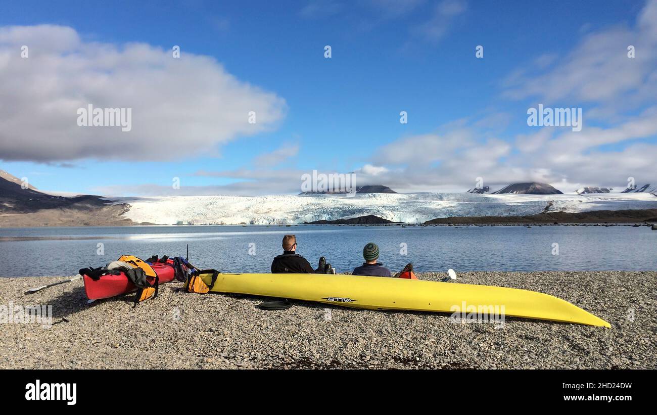 Kayak y 2 personas frente al Glaciar Nordenskiöld. Billefjorden, Svalbard, Spitsbergen, Noruega Foto de stock