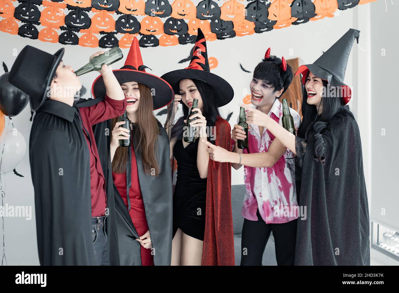 Pandilla de joven asiático en bruja de disfraces, mago con celebrar la  fiesta de Halloween para bailar y beber y borracho en la habitación. Grupo  adolescente tailandés con celebrar Fotografía de stock -