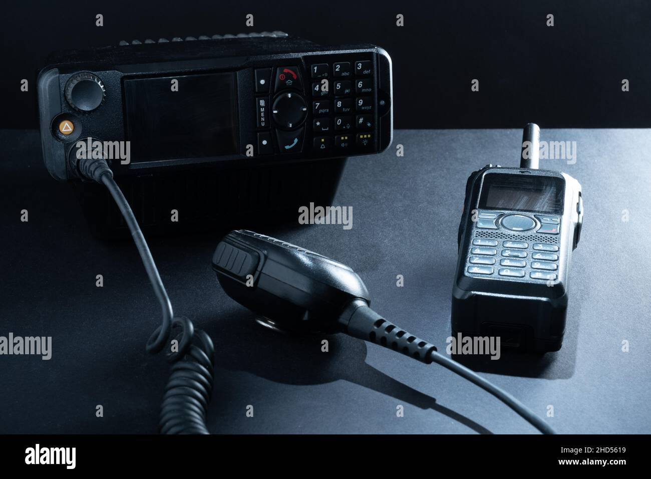 Helsinki / Finlandia - 3 DE ENERO de 2022: Primer plano de un par de radios bidireccionales móviles para operadores de radio amateur sobre un fondo oscuro. Foto de stock