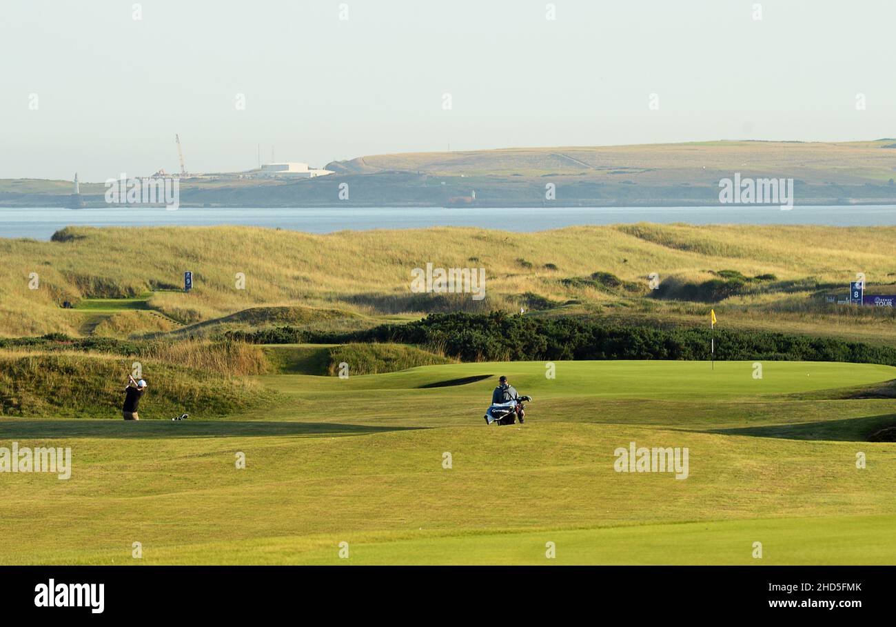 Golfers jugando al verde 1st (Bothy) en el campo de golf Murcar Links, Aberdeen, Escocia, un famoso campo de enlaces por el Mar del Norte, establecido en 1909. Foto de stock