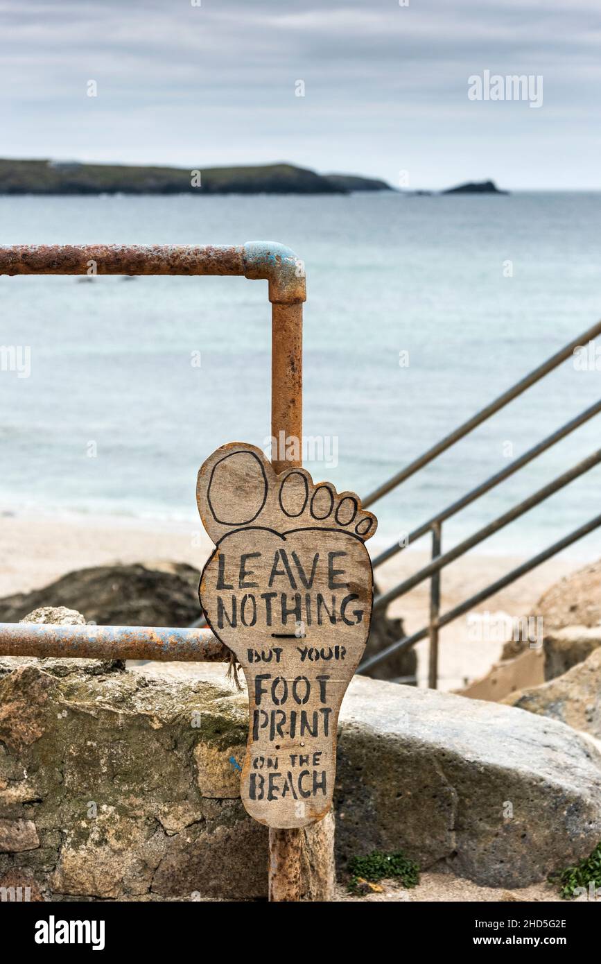 Un cartel de madera hecho a mano que recuerda a la gente que no deje basura en la playa de Little Fistral en Newquay en Cornwall. Foto de stock