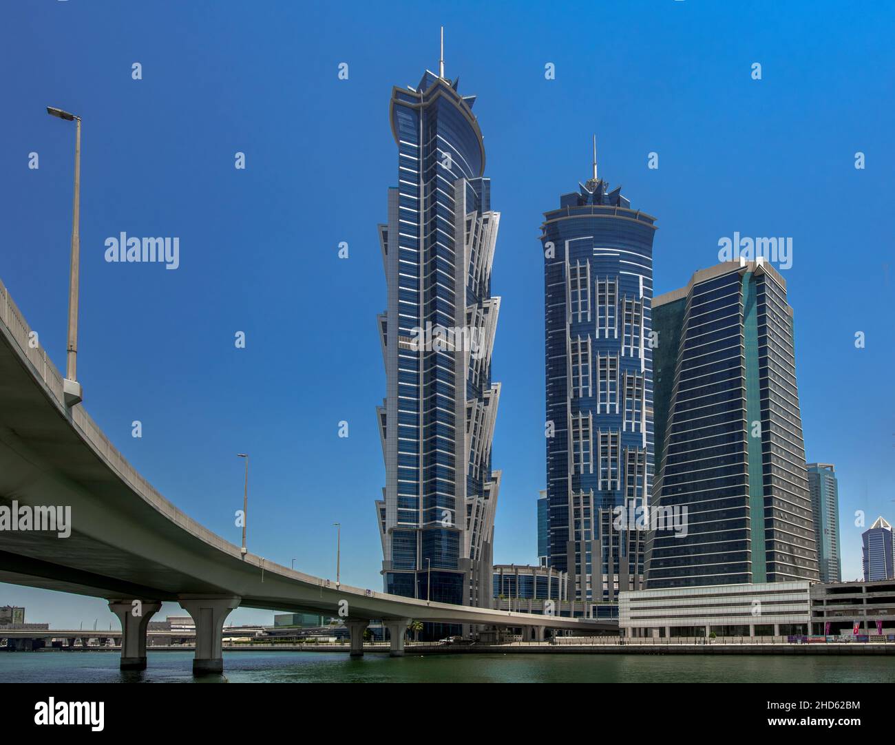 Puente curvo de hormigón cruzando el canal de Dubai y el principal distrito de negocios de Dubai Foto de stock