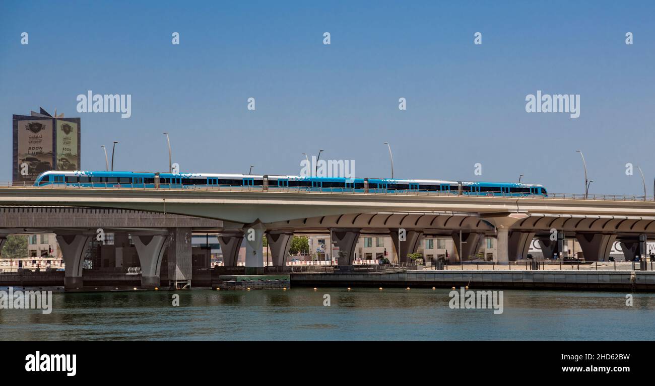 Metro de Dubai Cruzando el Canal de Dubai hacia el Distrito de Negocios de Dubai Foto de stock