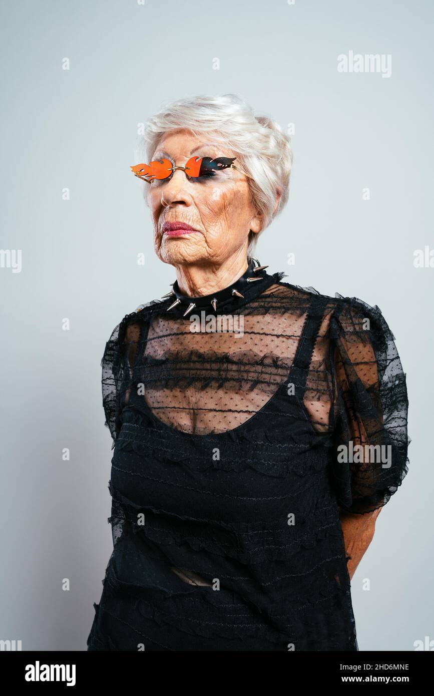 hermosa y elegante vieja mujer influyente. Abuela fresca posando en el con ropa moda. Feliz señora mayor celebrando y haciendo Fotografía de stock