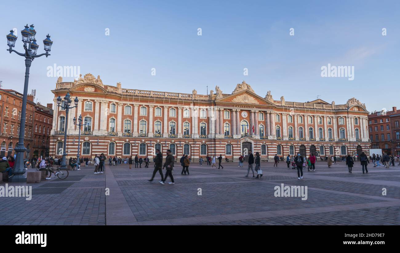 Place du Capitole y sus turistas, al atardecer, en Haute Garonne, en Occitanie, Francia Foto de stock