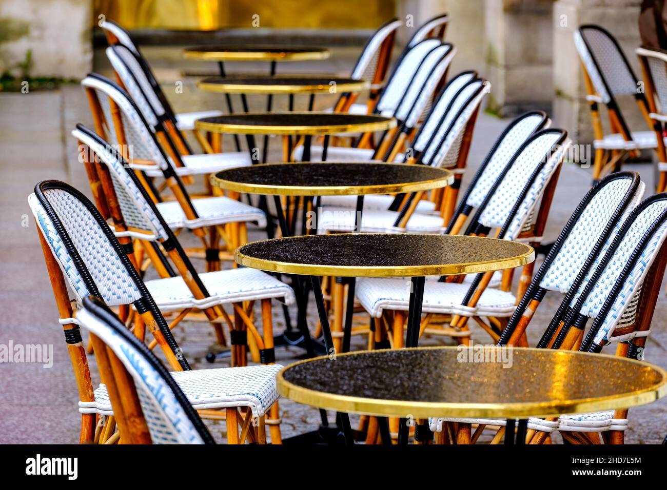 mesas y sillas en la fila - restaurante francés después de la lluvia Foto de stock