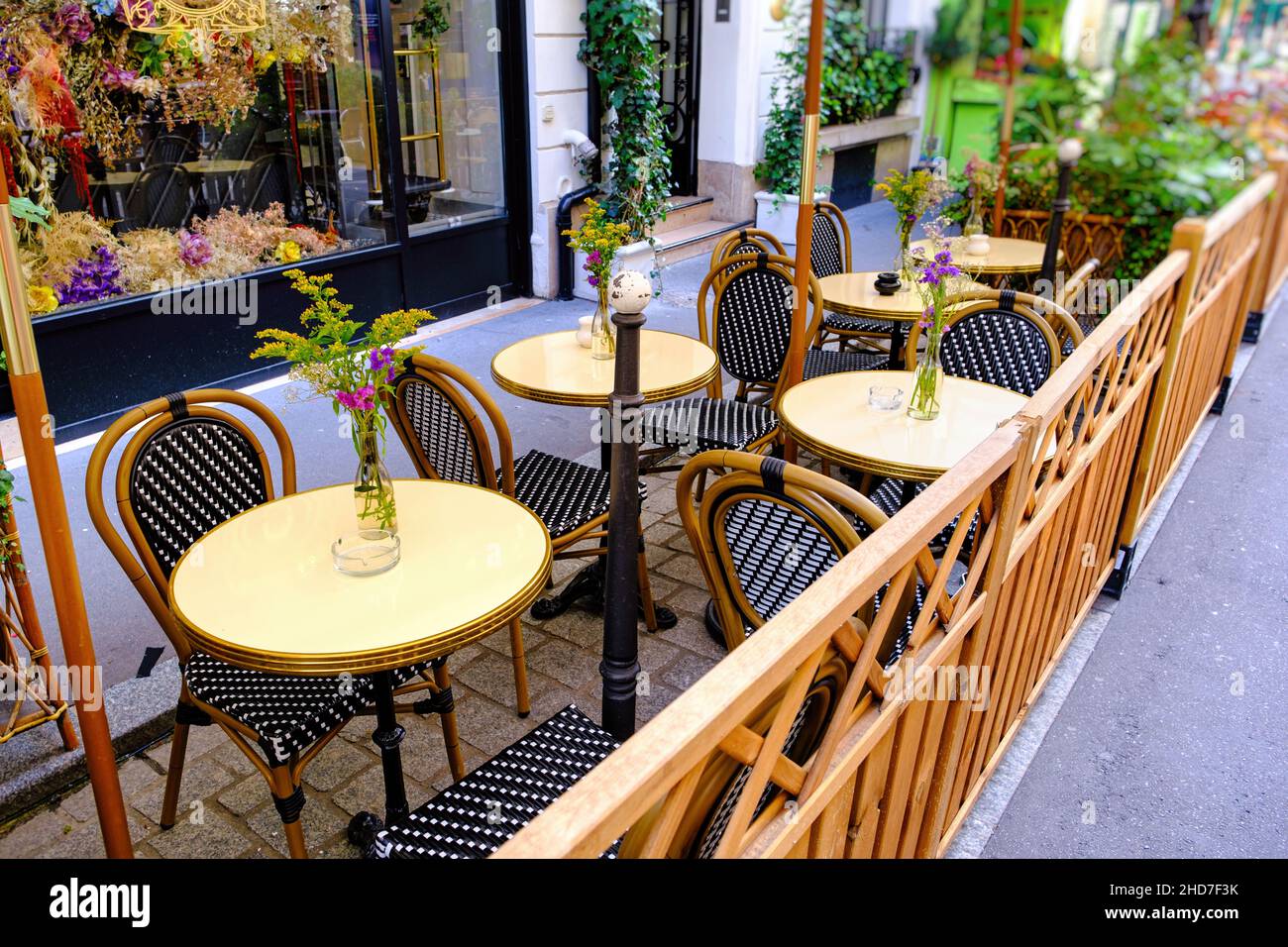 Patio de un restaurante francés con mesas decoradas con flores Foto de stock