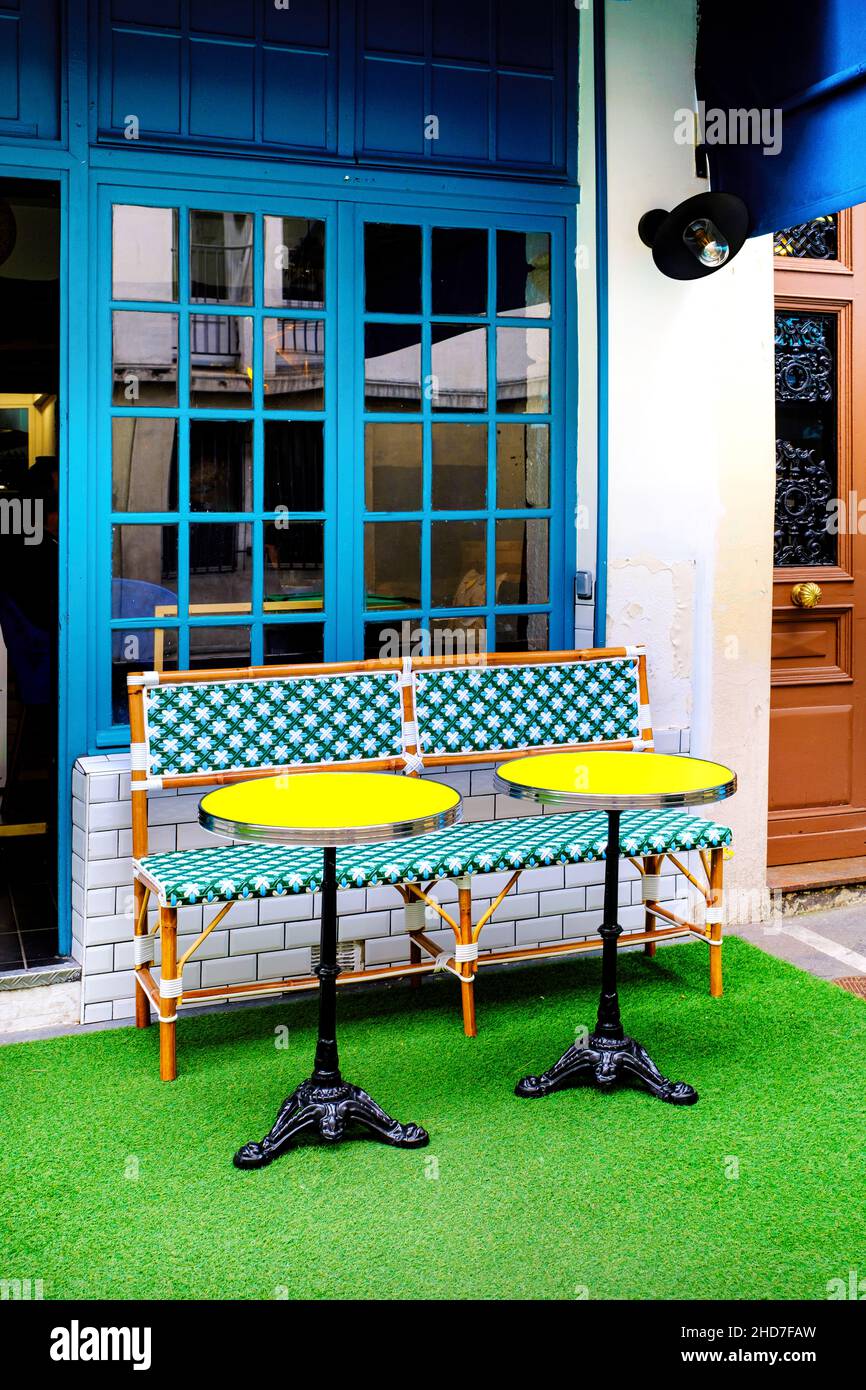 Mesas amarillas y un banco - pequeño café francés, París Francia Foto de stock