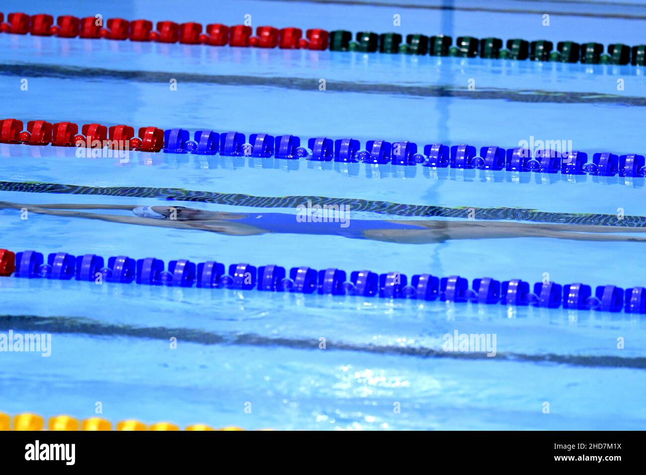 Nadadora femenina buceando bajo el agua en una piscina cubierta Foto de stock