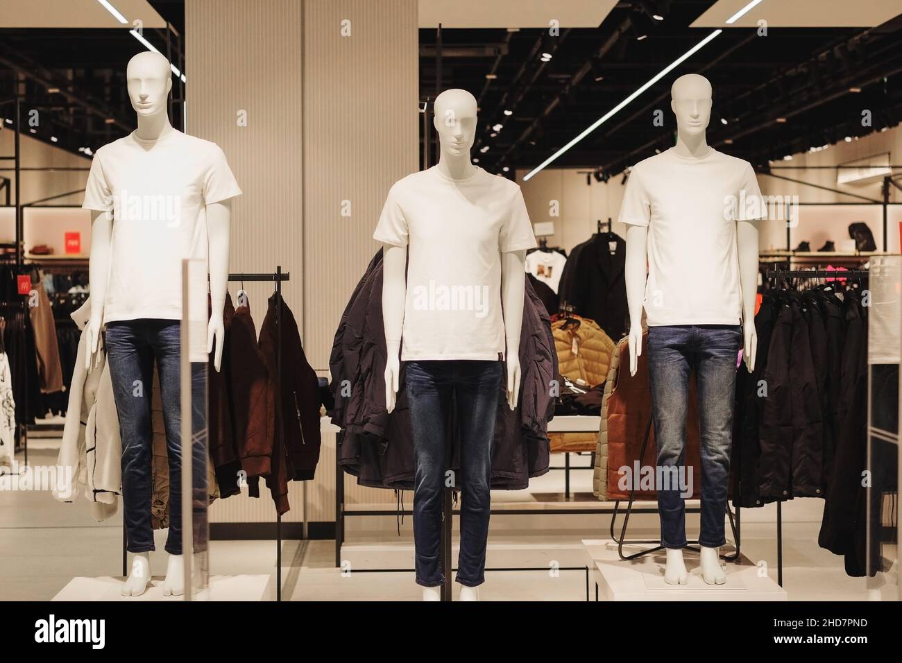 Los maniquíes masculinos de ropa informal se ponen de pie en una tienda de ropa. Maniquíes en el gran centro comercial. Foto de stock