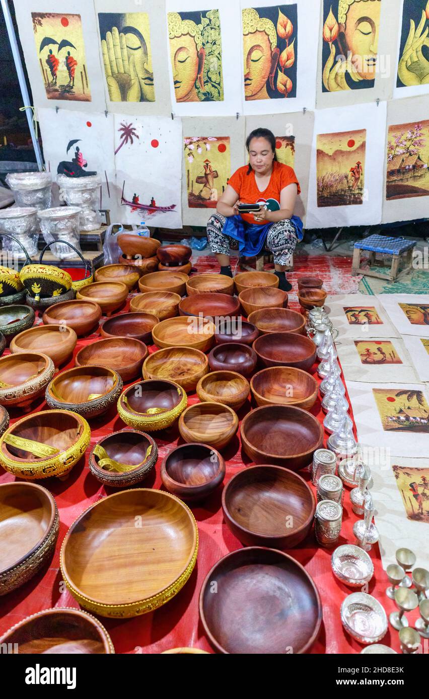Exposición de tazones de madera típicos, cuadros y recuerdos en el mercado nocturno de la calle peatonal en el centro de Luang Prabang, norte de Laos, sudeste de Asia Foto de stock