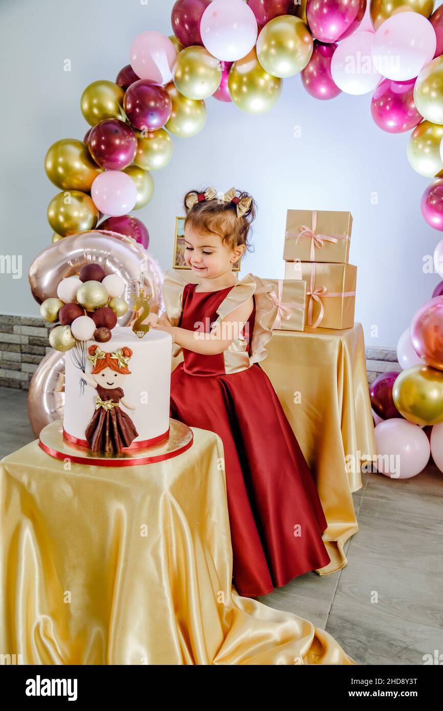 feliz cumpleaños niña de 2 años con vestido rosa. pastel blanco