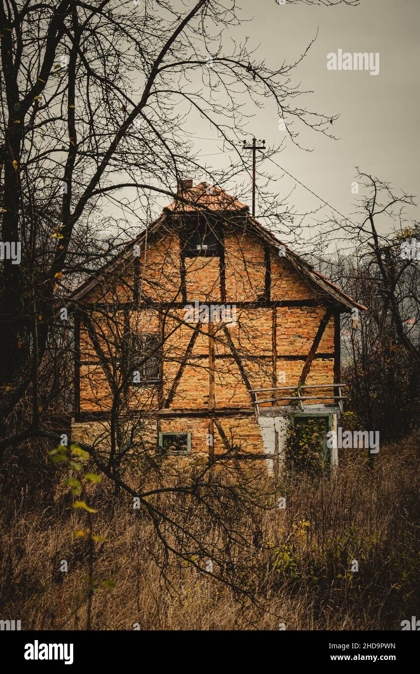 Foto vertical de una antigua casa en el campo con hermosos colores otoñales Foto de stock