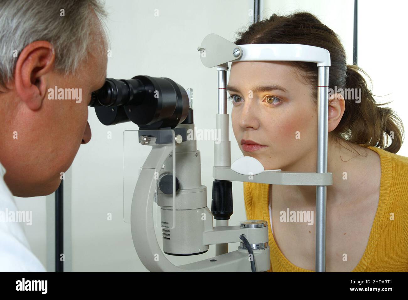 Ein Augenarzt untersucht die Augen seiner Patientin Foto de stock