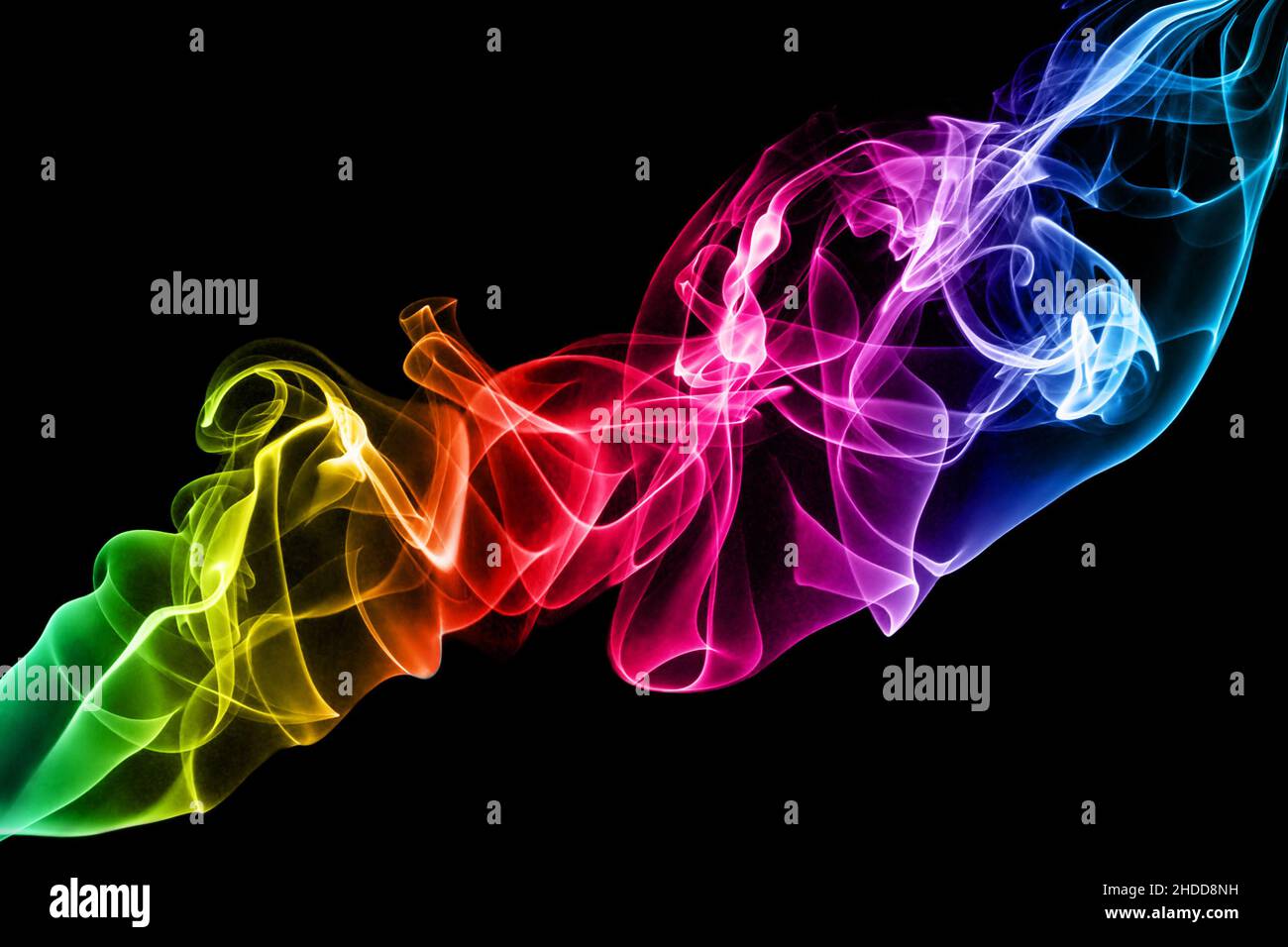 Un colorido diseño de espiral de humo en colores de gradiente de arco iris sobre fondo negro. Foto de stock