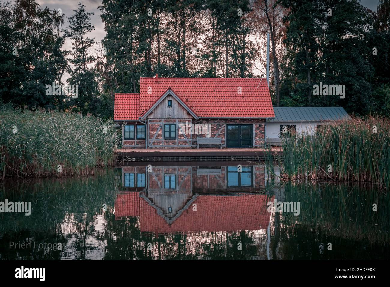 Hermosa foto de una casa de madera con lago en primer plano Foto de stock