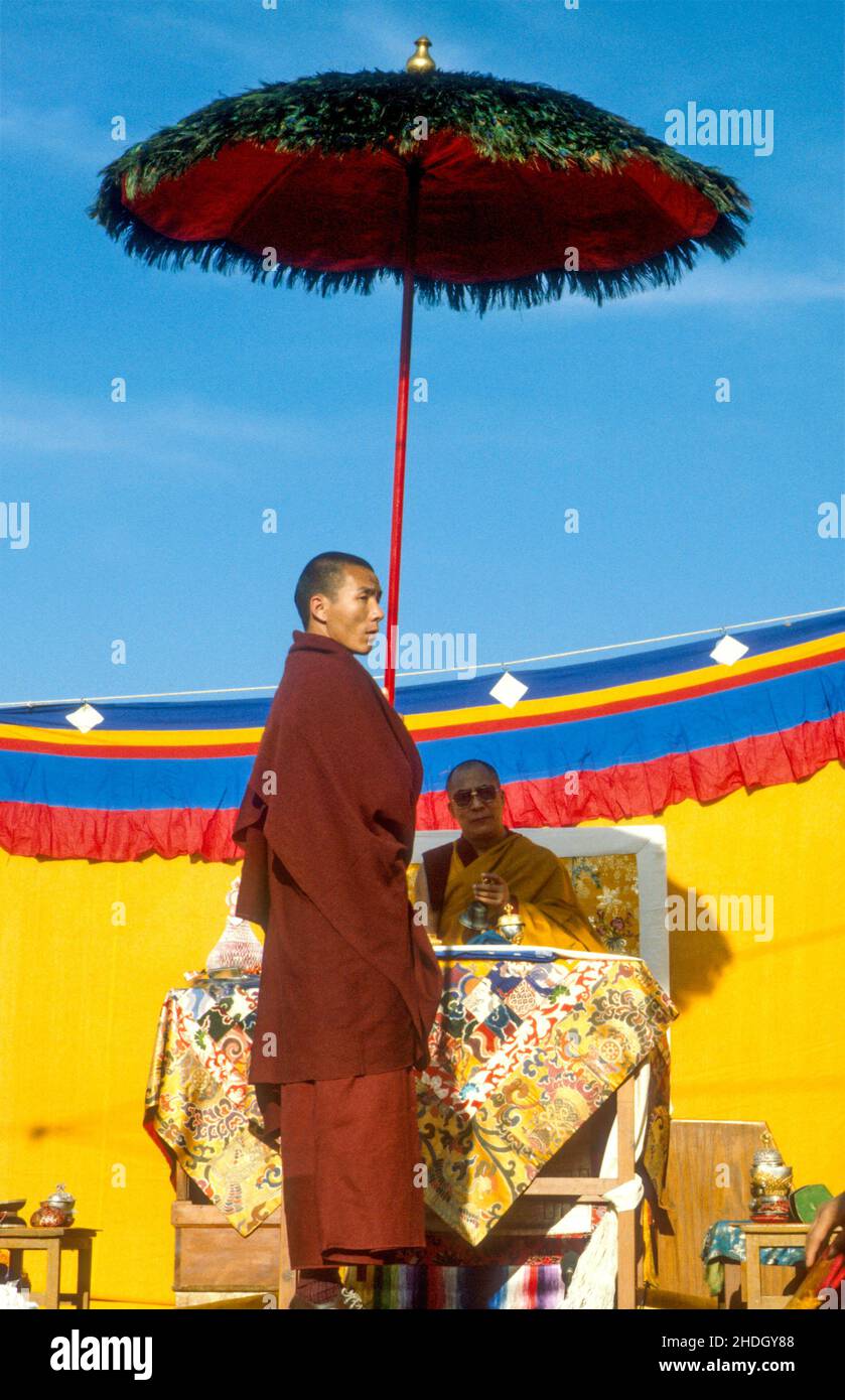 H. H.Dalai Lama en su trono a la sombra de un monje que sostenía un paraguas de plumas de pavo real en una ceremonia para Tibetan N. Year. Dharamsala, Himachal Pradesh, India Foto de stock