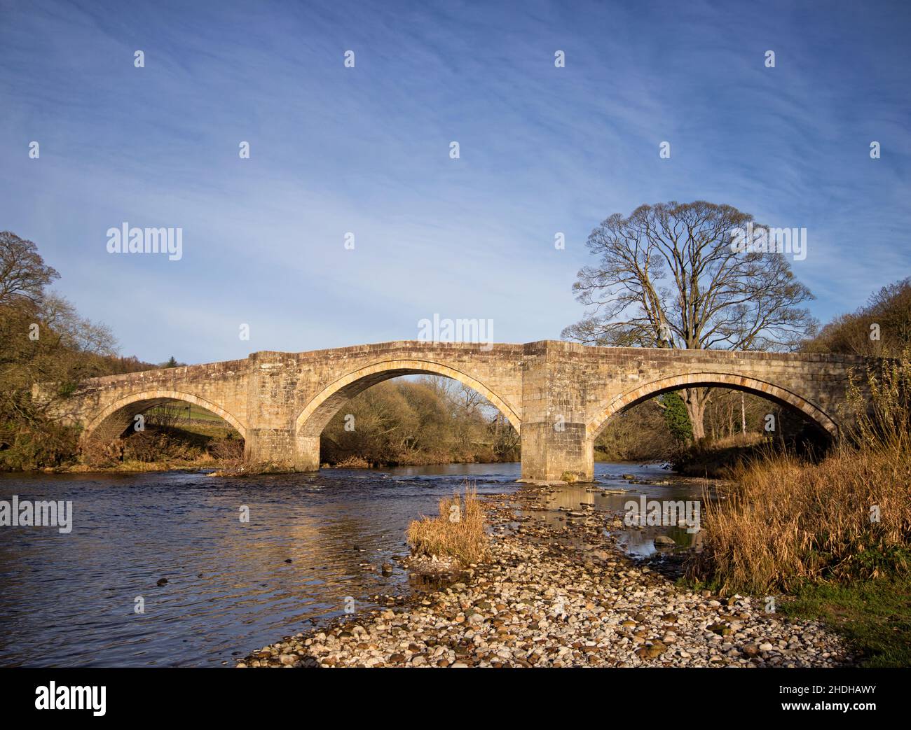 El elegante e histórico Barden Bridge, que atraviesa el río Wharfe en Barden, Skipton, Reino Unido. Este histórico puente limita con los terrenos de la Abadía de Bolton. Foto de stock