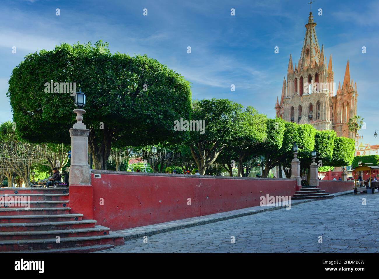 La Iglesia Parroquia de San Miguel Arcángel, de color rosa neogótico, tiene vistas al bien cuidado El Jardin, el jardín de San Miguel de Allende, México Foto de stock