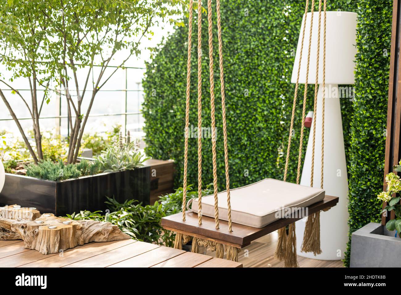 Acogedora terraza con columpio de madera en el jard n y una