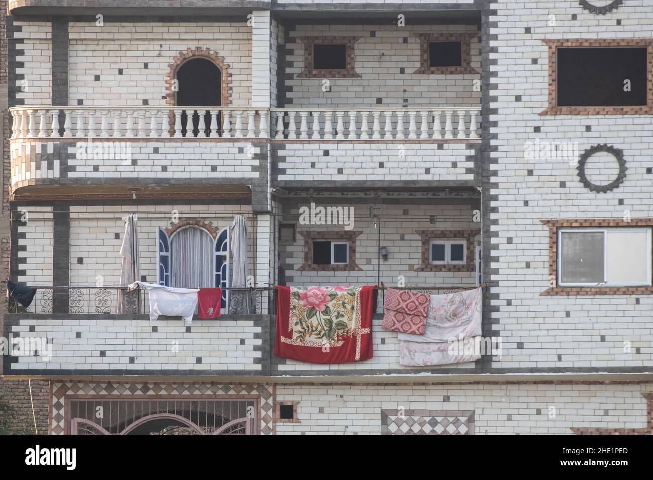El exterior de un bonito edificio residencial con ladrillos blancos y balcones en Egipto. Foto de stock